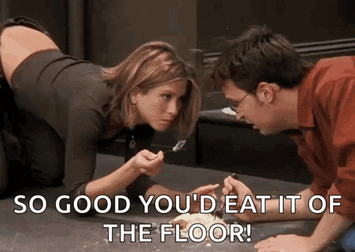 a man and a woman are sitting on the floor eating food with a fork .