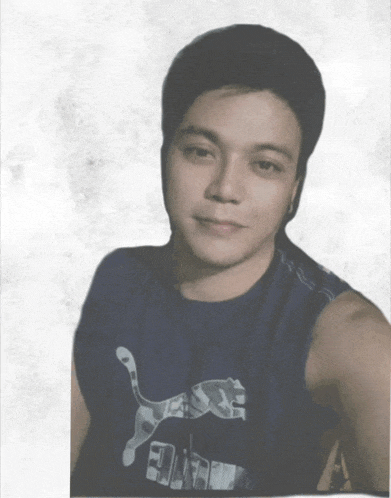 a man wearing a blue puma tank top looks at the camera