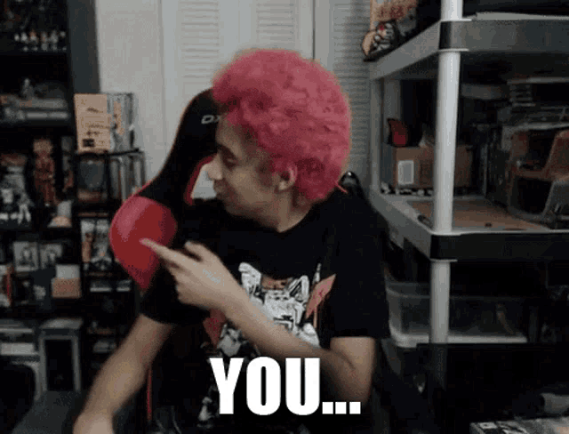 a man with pink hair is pointing at the camera and says you