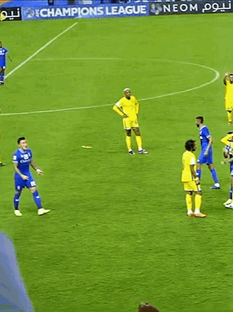 a group of soccer players on a field with an ad for champions league behind them
