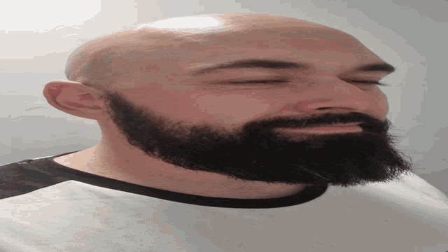 a bald man with a beard is laying down