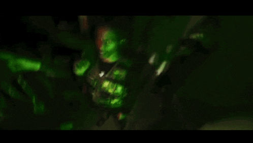 a man is holding a gun in a green room