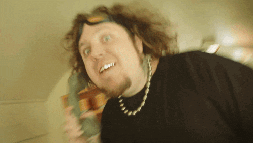 a man with a beard and goggles on his head is talking on a phone