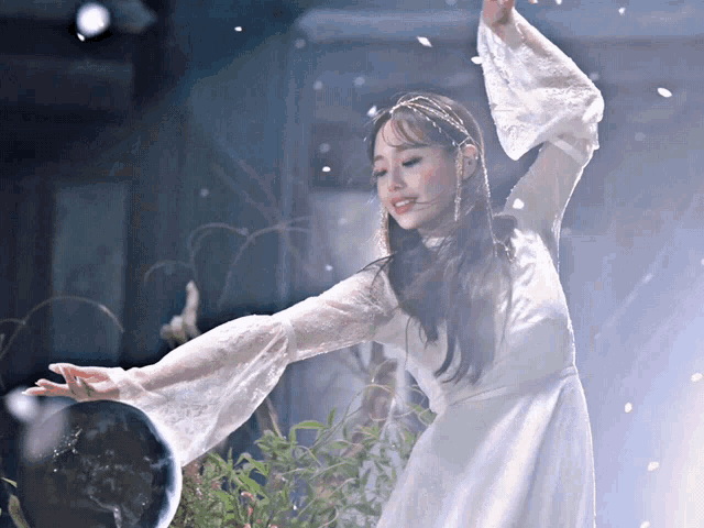 a woman in a white lace dress is dancing in front of a globe