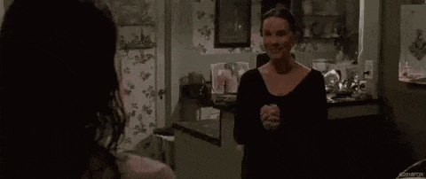 a woman is crying in a kitchen with her eyes closed and her mouth open .