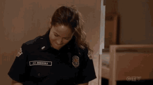 a woman in a firefighter uniform is looking at her cell phone