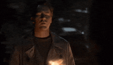 a man with his eyes closed is surrounded by flames on his chest .