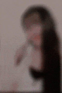 a blurry picture of a woman 's face with a red lip .