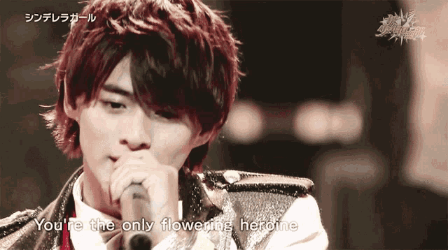a man singing into a microphone with the words you 're the only flowering heroine
