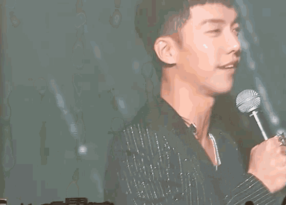 a close up of a man holding a microphone in his hand
