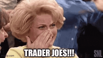 a woman is covering her mouth with her hand while sitting in a crowd of people .