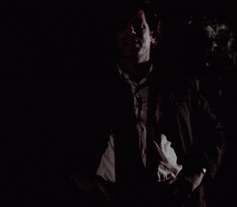 a man in a suit and tie in the dark