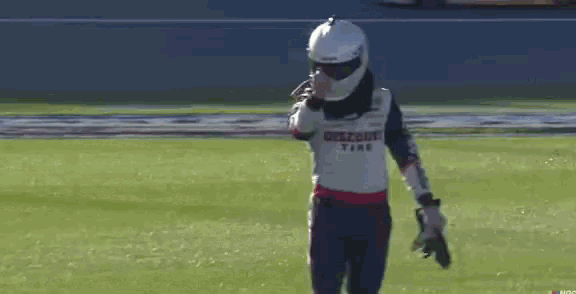 a person wearing a helmet and holding a paintball gun on a field .