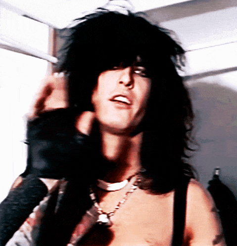 a close up of a man 's face with long black hair