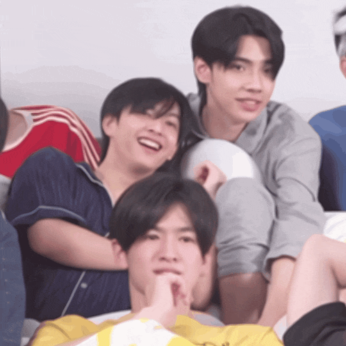 a group of young men are posing for a picture and one is wearing a yellow shirt