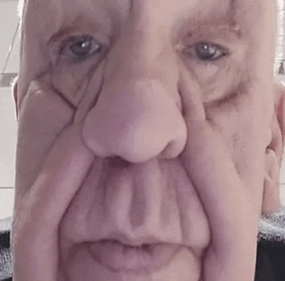 a close up of a man 's face with a very large nose .