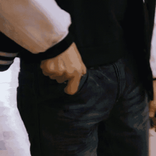 a person 's hand is sticking out of the back pocket of their jeans