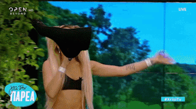 a woman covering her face with a black cloth on a tv screen that says open hd