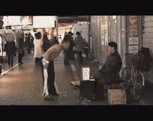a man without a shirt is bowing to another man