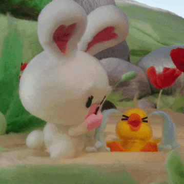 a stuffed bunny and a stuffed duck are sitting on a table
