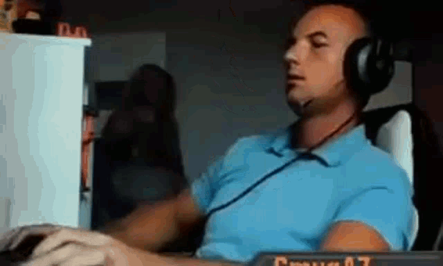 a man wearing headphones is sitting in front of a computer keyboard .