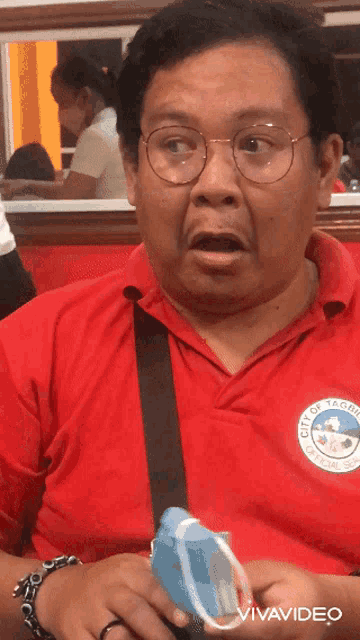 a man wearing a red shirt that says city of taguig on it
