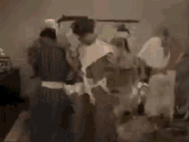 a group of people are standing in a room dancing .