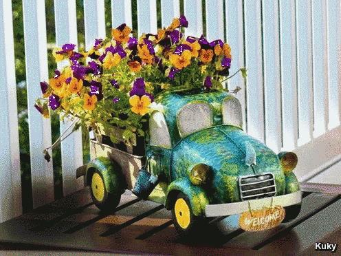 a green car with flowers in it and a welcome sign