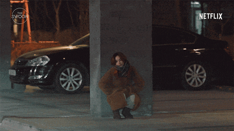 a woman leaning against a pillar next to a car with netflix written in the corner