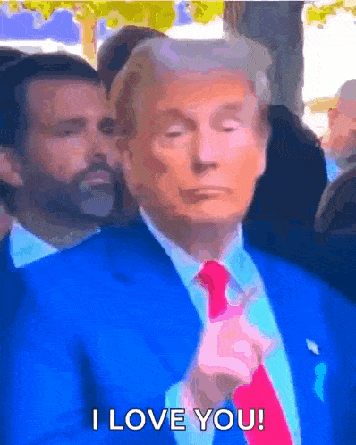 a man in a blue suit and red tie is saying i love you