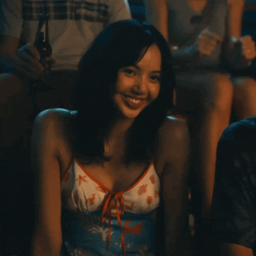 a woman in a blue and white tank top smiles