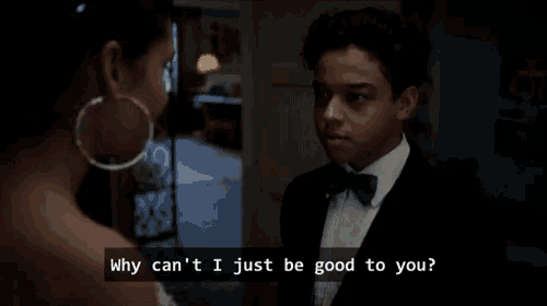 a man in a tuxedo is talking to a woman who is wearing hoop earrings ..
