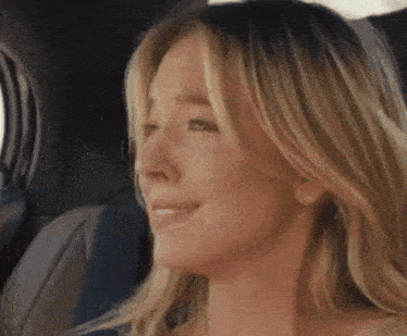 a woman is crying while sitting in a car seat .