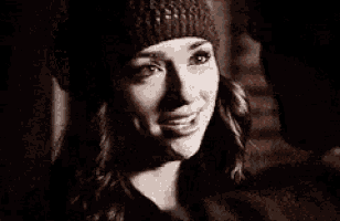 a close up of a woman wearing a knitted hat and smiling .