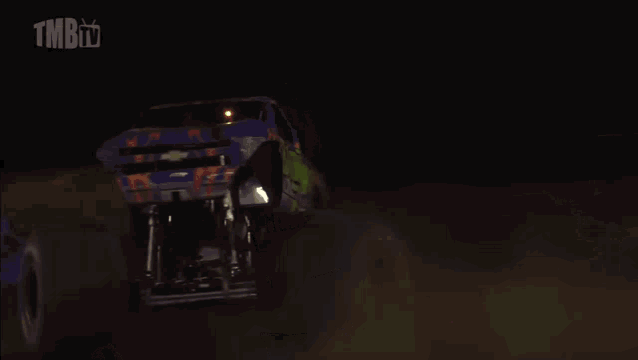 a woman stands in front of a barbarian monster truck