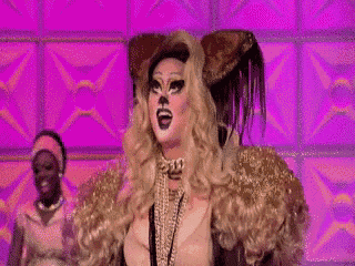 a drag queen is wearing a cat costume with a cat face on her face .