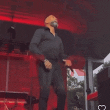 a man with a beard is dancing on stage in front of a microphone .