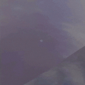 a man is flying through the air with his arms outstretched in a dark room .