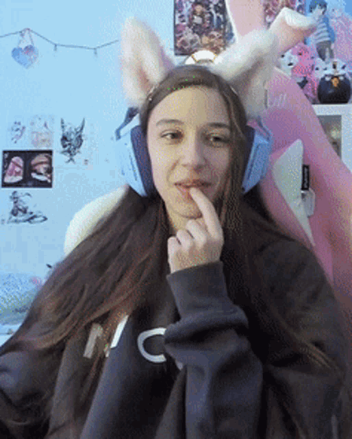a woman wearing bunny ears and headphones has the letter c on her sweatshirt