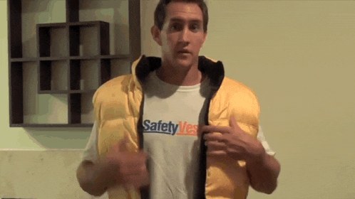 a man wearing a yellow vest with safety vest written on it