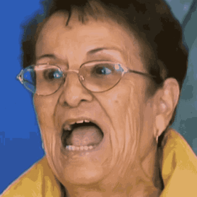 an elderly woman wearing glasses is making a funny face with her mouth open