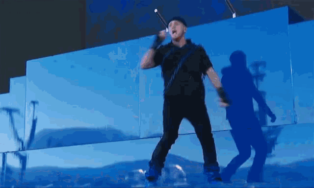 a man standing in front of a blue wall