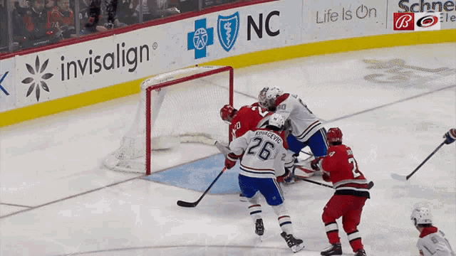 a hockey game is being played in front of an invisalign banner