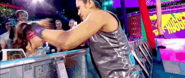 a man is holding a woman 's head in a wrestling ring .