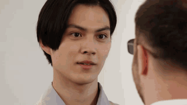 a man looking at another man with glasses on
