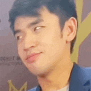 a close up of a man 's face making a funny face while wearing a blue suit .