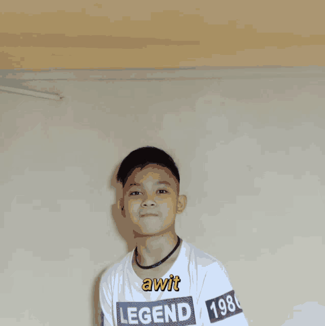 a boy wearing a white shirt with legend on it