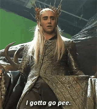 a man in a crown is sitting on a chair and saying `` i gotta go pee '' .