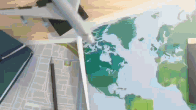 a plane is flying over a map of the world on a desk