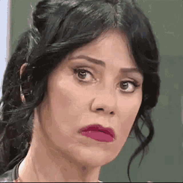 a close up of a woman 's face with a ponytail and pink lipstick .